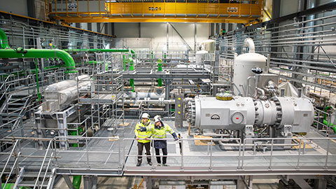 Picutue of heat pump with two workers in front