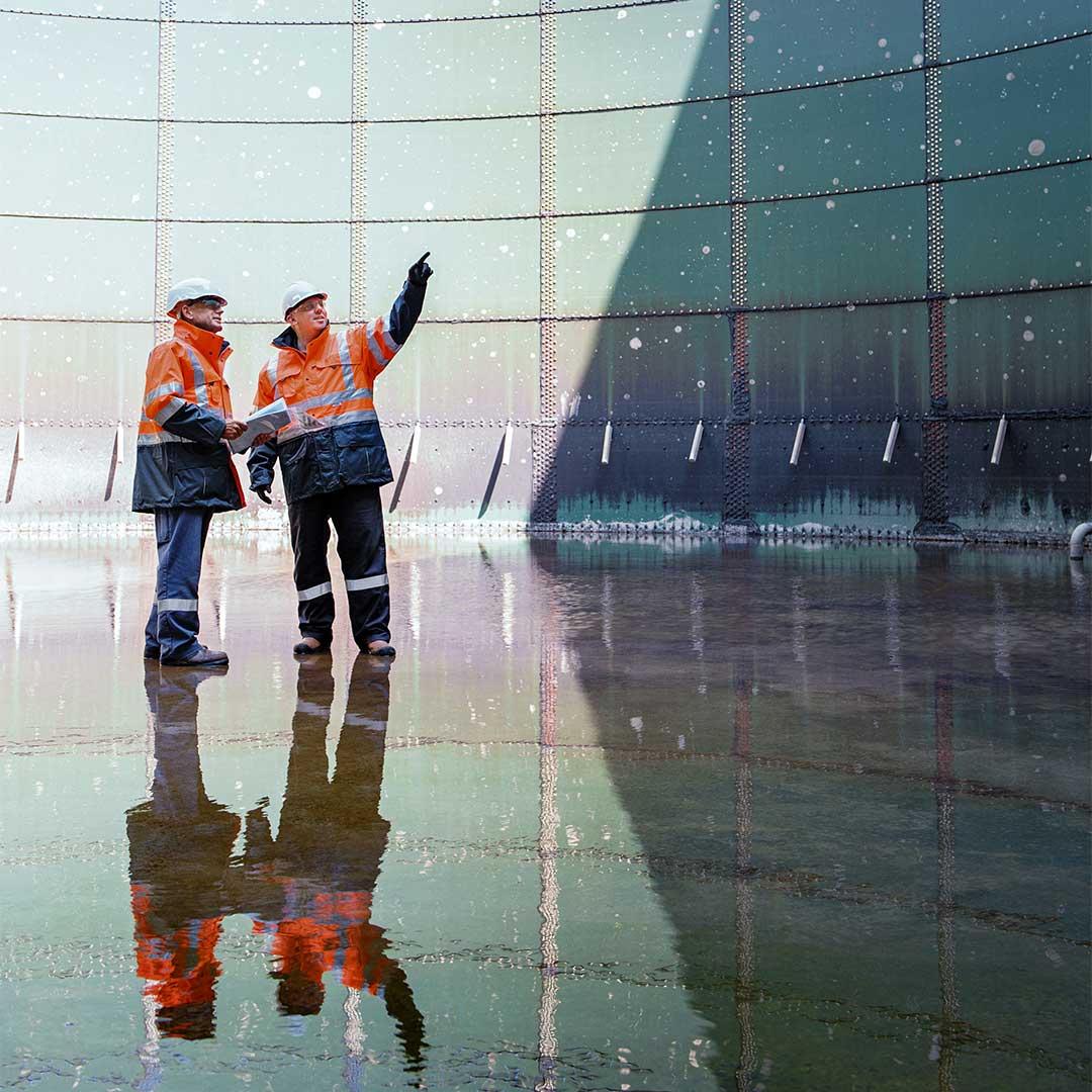 Two workers in front of a cooling tower