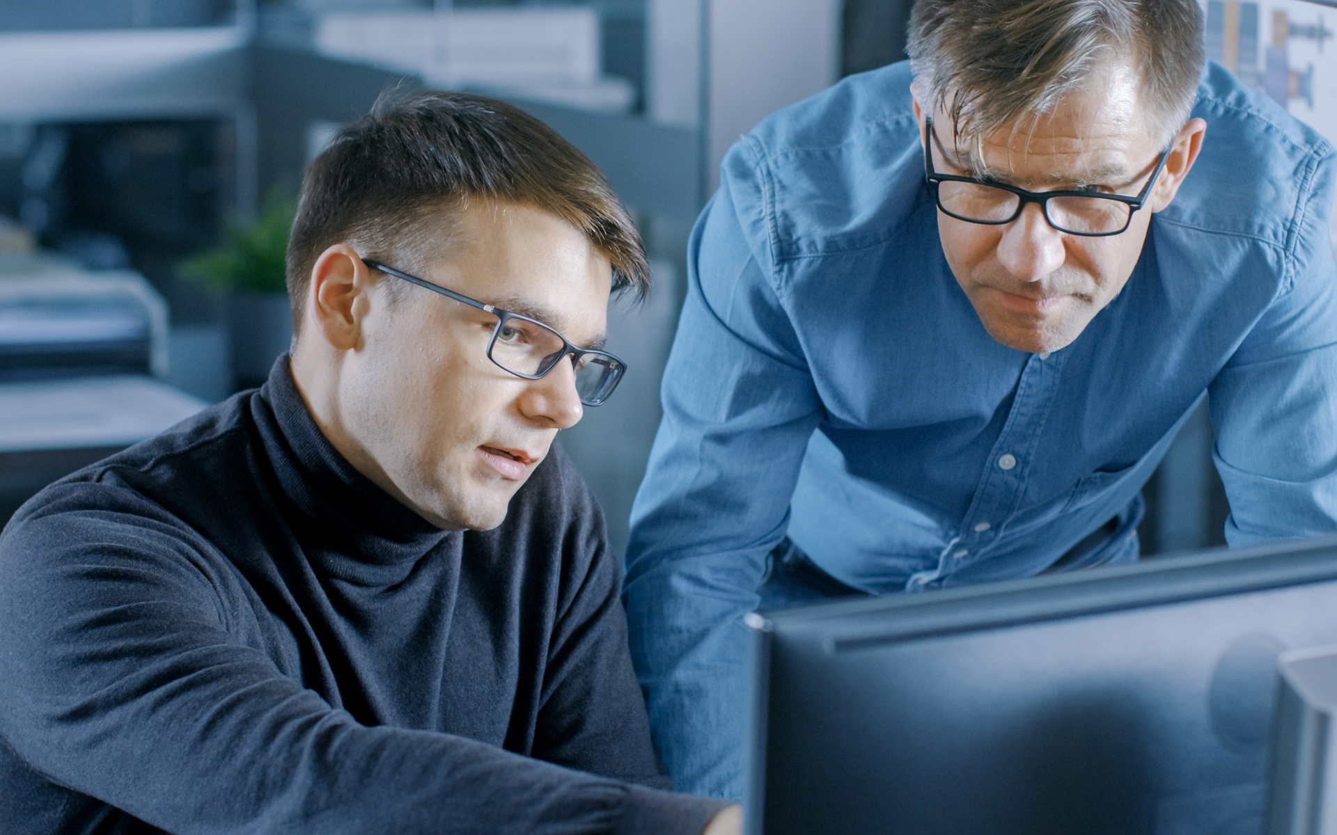 two men looking at a computer screen