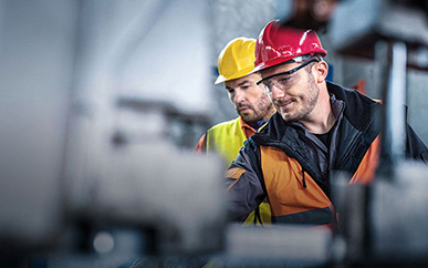 Two men behind a blurred machine