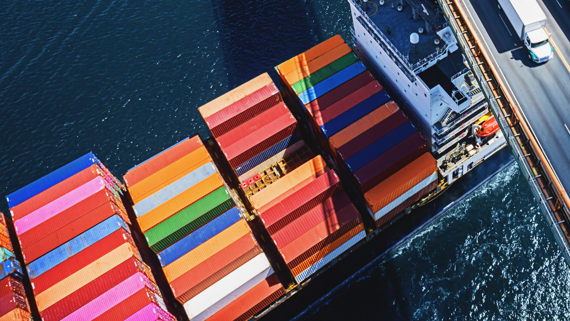 A container ship sailing under a bridge.