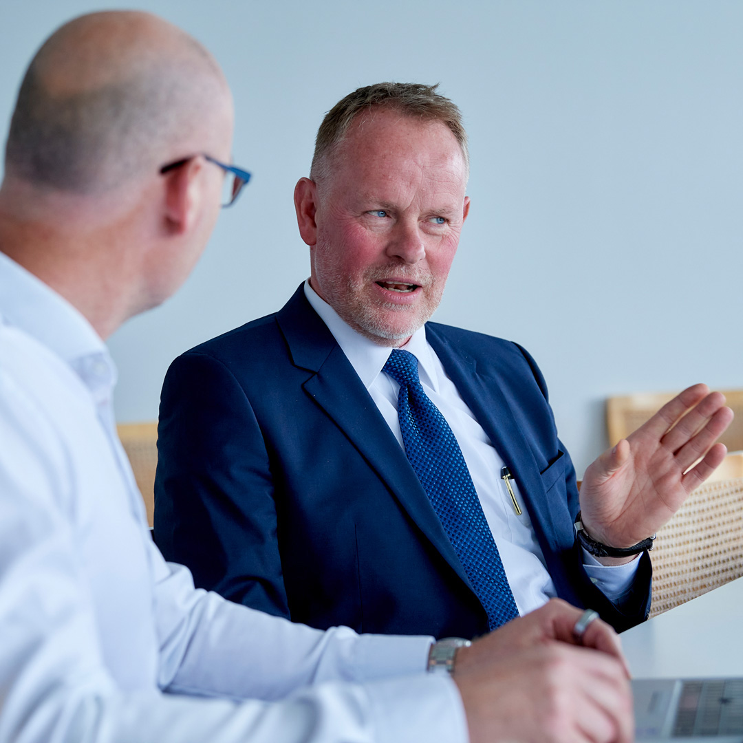 Two men in business suits are talking.