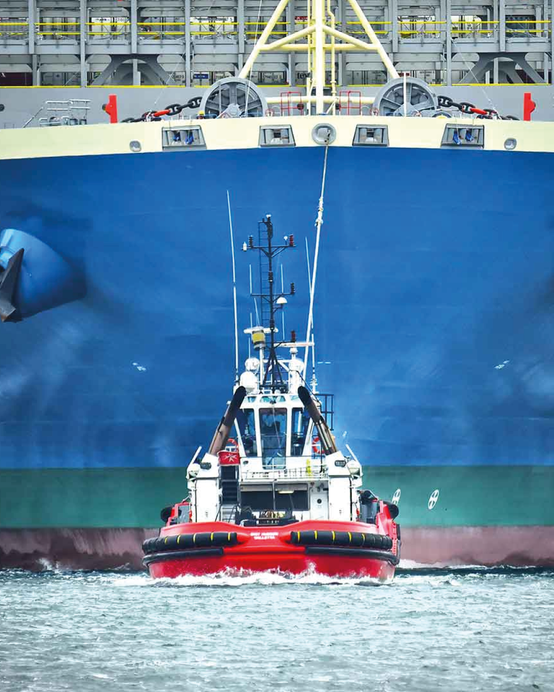 Tug in front of a cargo ship