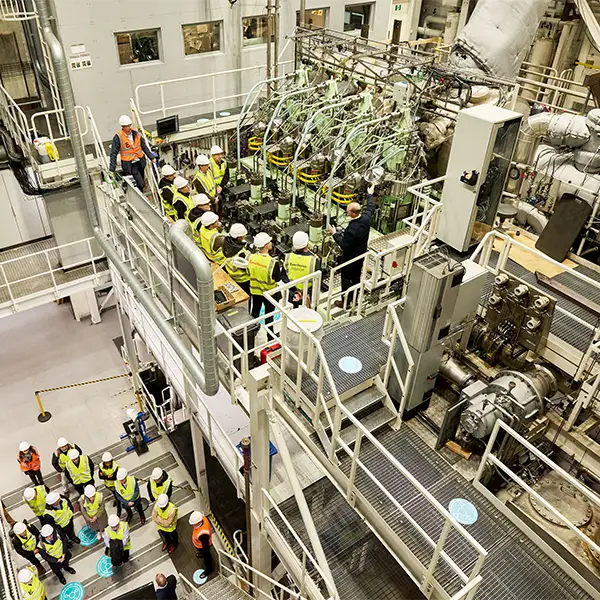 group of people next to engine on testbed