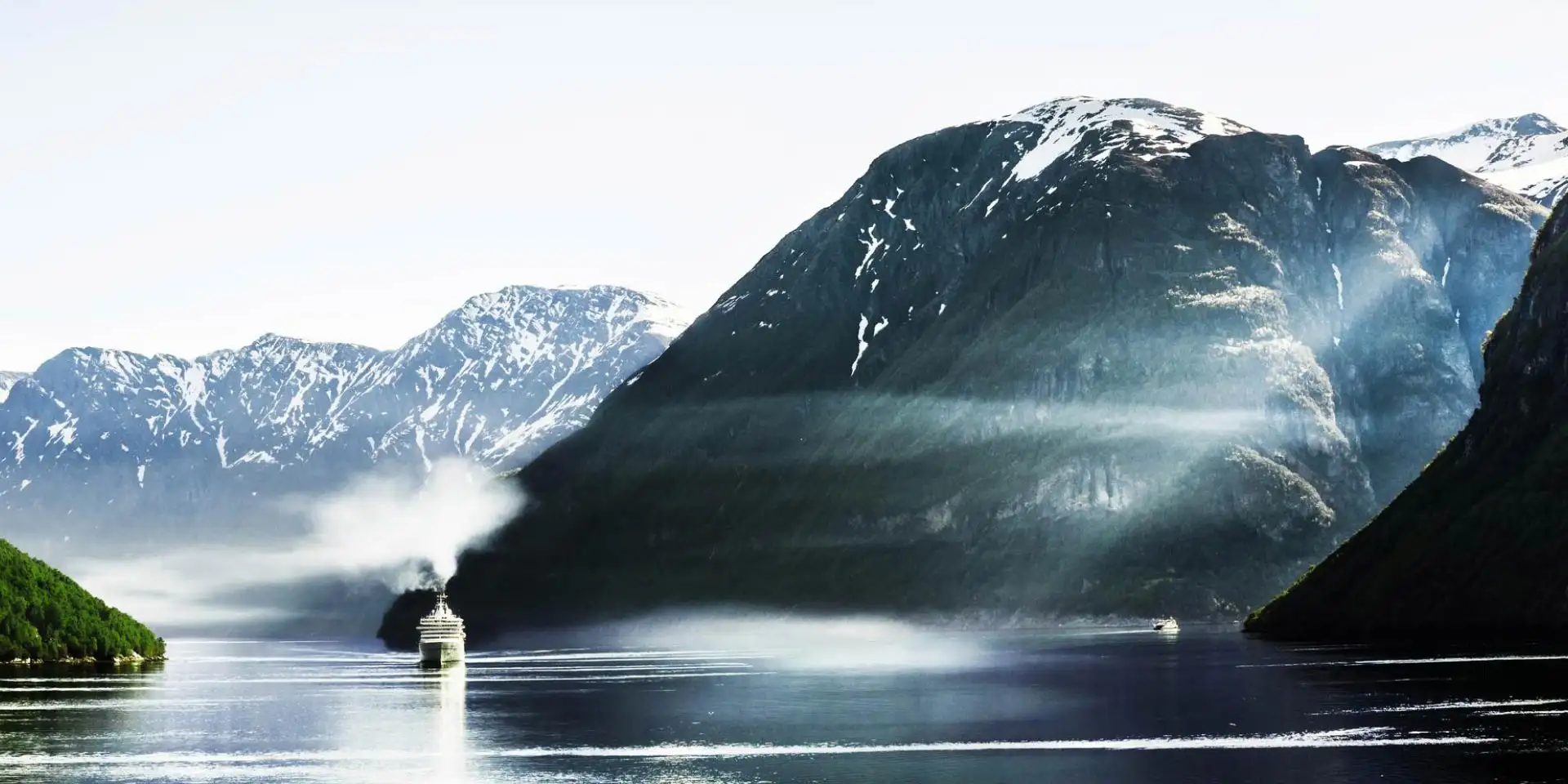 ship cruising through  a fjord