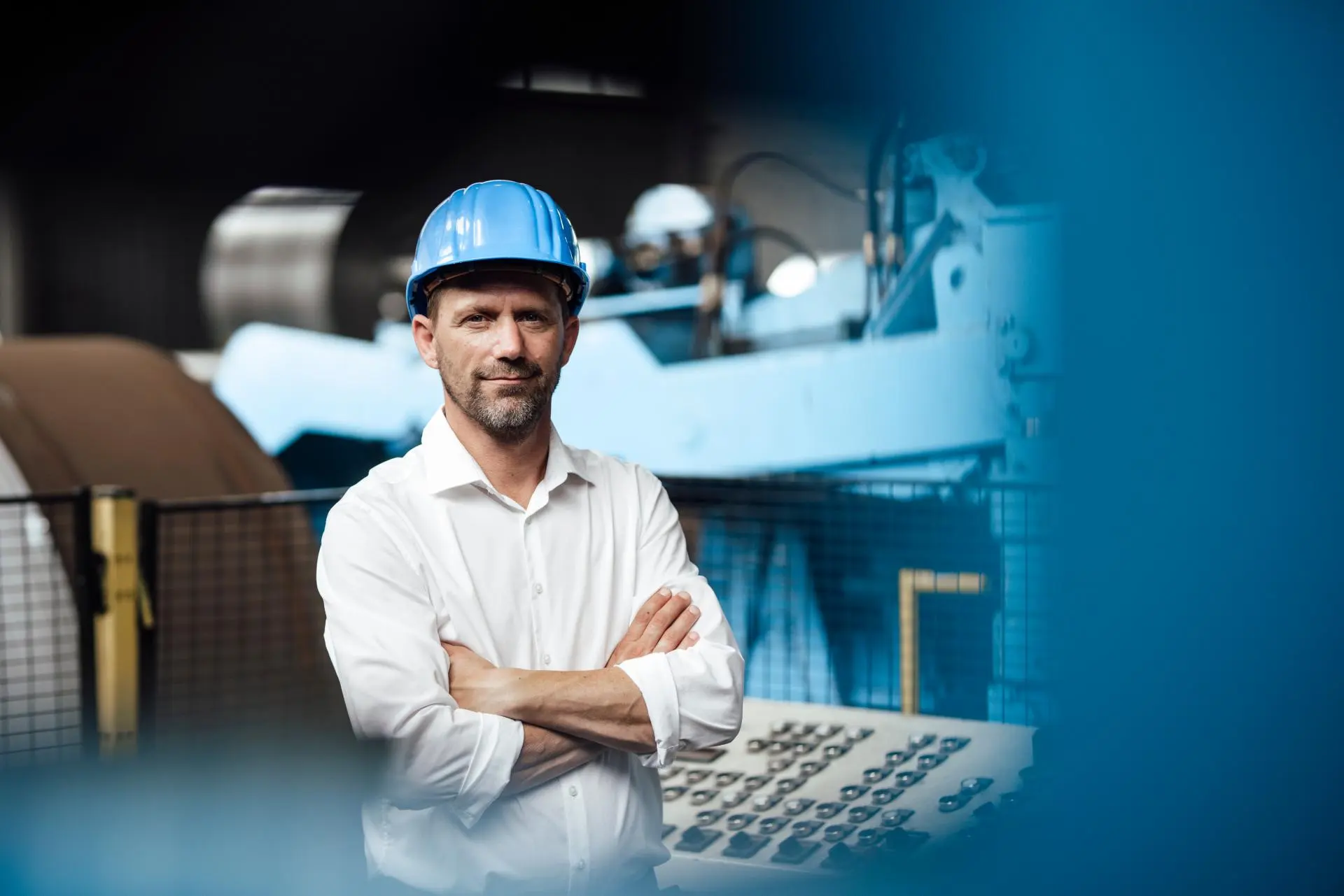 Engineer in hard hat standing with arms crossed.