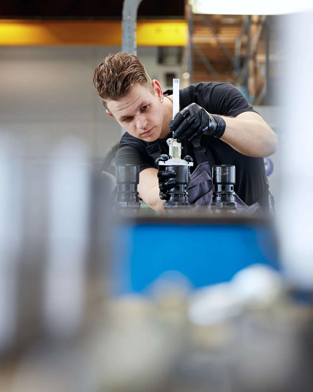 Technician measuring engine components during technical service inspection.